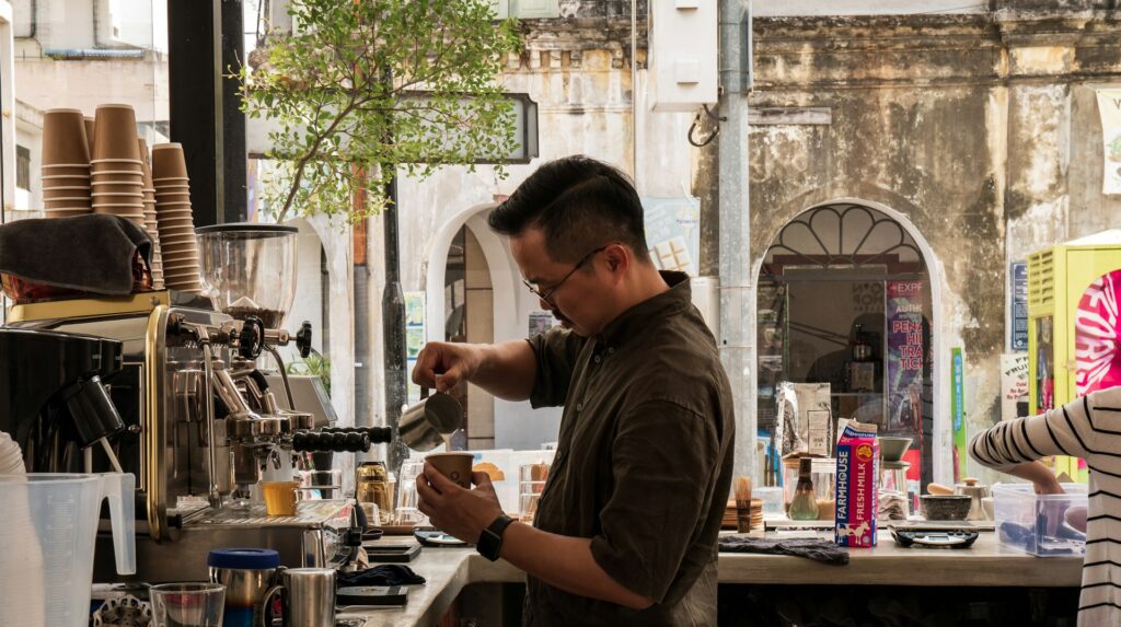 Barista pouring steamed milk in a cafe