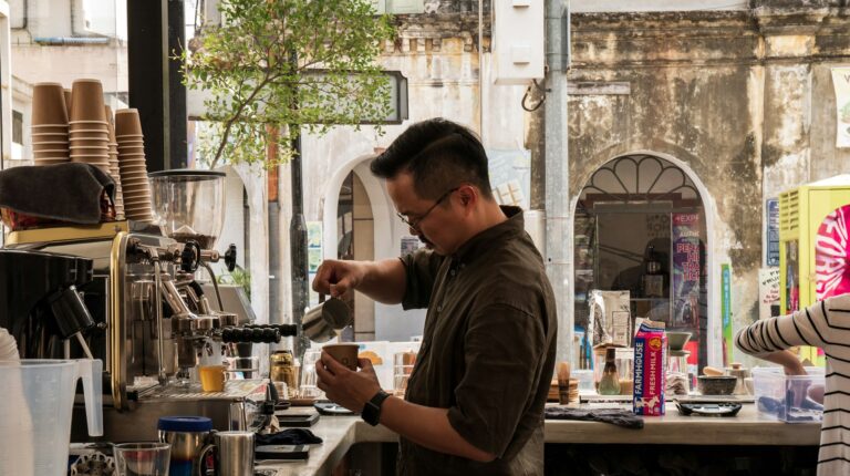 Barista pouring steamed milk in a cafe