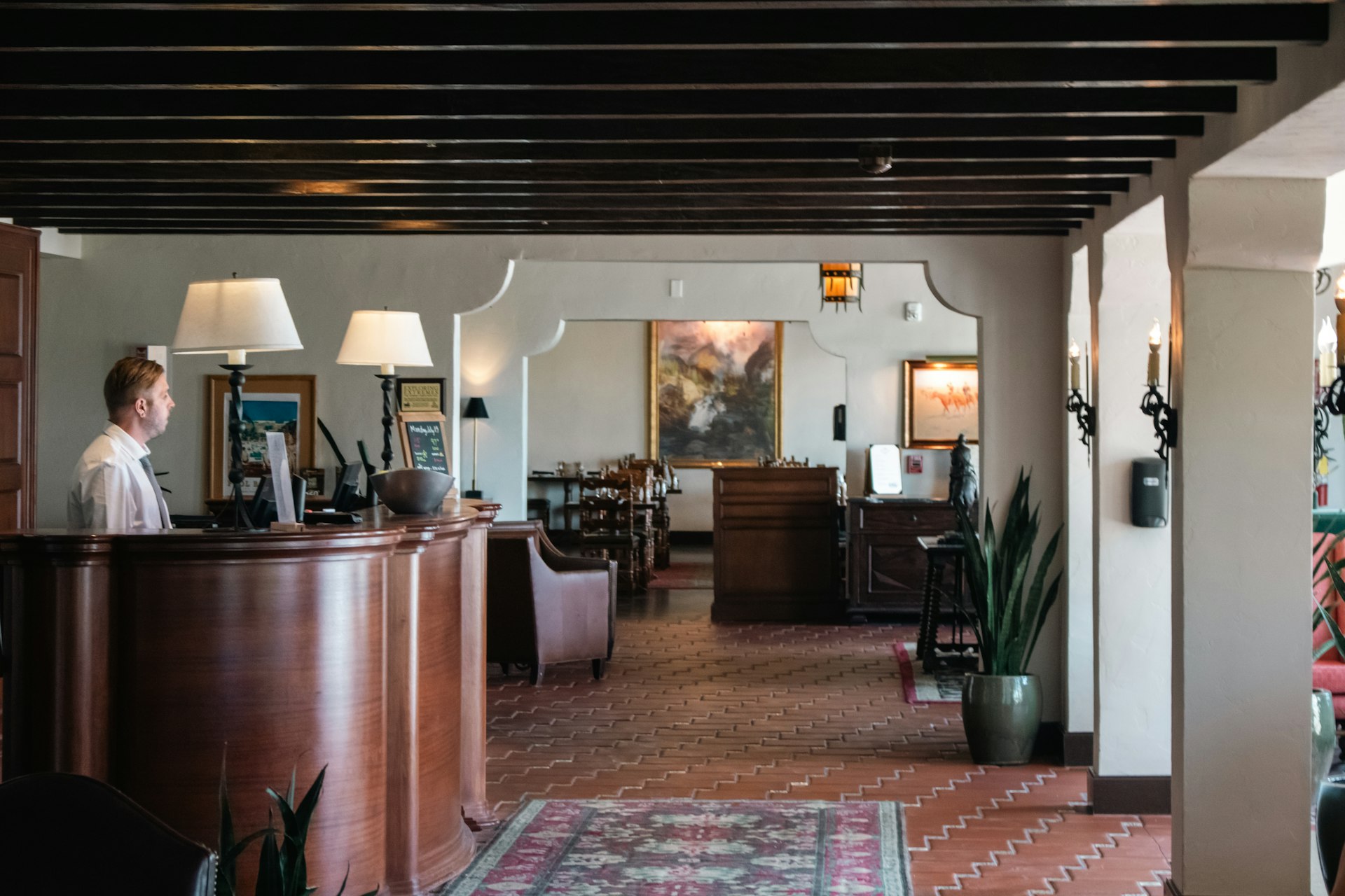 Hotel receptionist welcoming a guest at the front desk