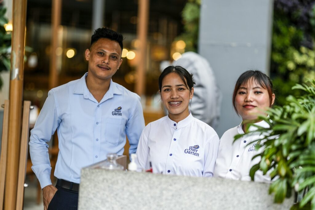 Smiling hospitality team behind a counter